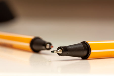 A closeup shot of white-yellow stripes pens on a white blurred backgroundの写真素材