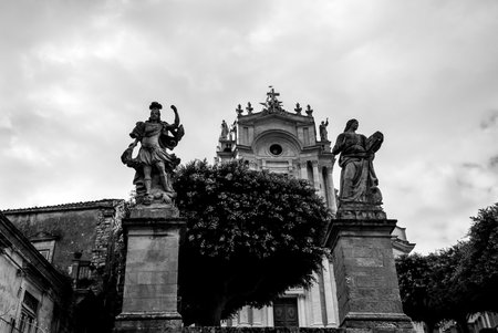 A low angle monochrome shot of unique baroque sculptures in front of the San Giovanni church in Ragusa Province, Italyの写真素材