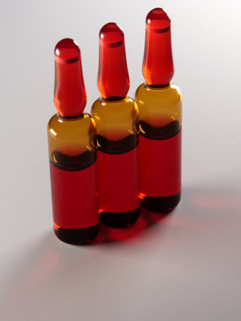 A vertical shot of three red ampoules isolated on a white backgroundの写真素材