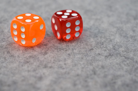 A pair of red and yellow dice on a gray backgroundの写真素材