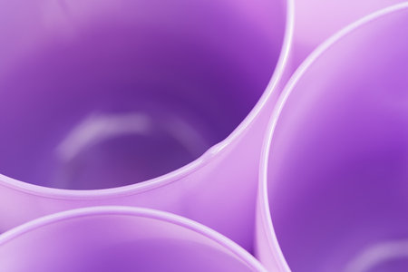 A closeup of purple glass cups grouped tightly together with light falling on themの写真素材
