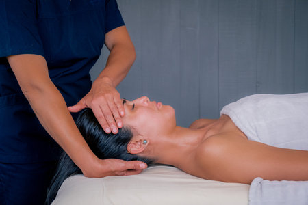 cervical relaxation massage, in beautiful young brunette latina woman, brown skinの写真素材