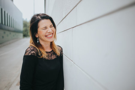 A closeup shot of a white Caucasian woman wearing a black dress and smiling