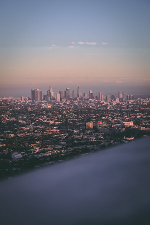 A vertical aerial shot of the cityscape of Los Angeles captured on a foggy dayの写真素材
