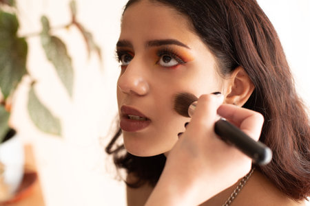 An attractive brunette Hispanic girl getting her makeup done