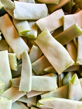 A vertical shot of sliced green beans on a bowl