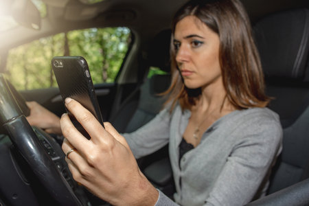 A female Caucasian driver talking on the phone and driving a car