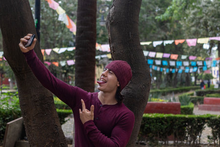 A young man with a beanie taking a photo of himself with a cellphone