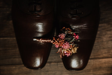 A small gentle boutonniere on the new shoes for the groomの写真素材