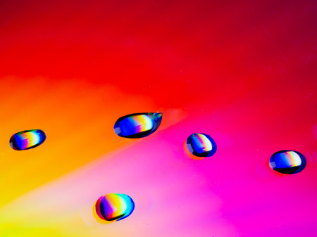 Close-up of water drops on a red and yellow colored surface