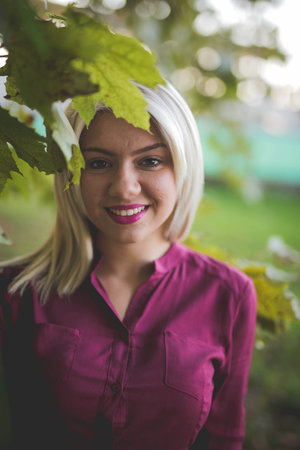 A portrait of a beautiful blonde hair female in a pink shirtの写真素材