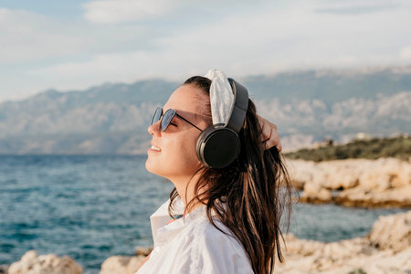 A Caucasian female with headphones on a beach in Croatiaの写真素材