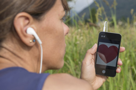 Woman Using Smartphone with Heart shape in Switzerland.の写真素材