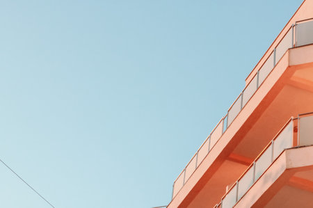 A low angle shot of the balconies of a modern building against the clear blue skyの写真素材