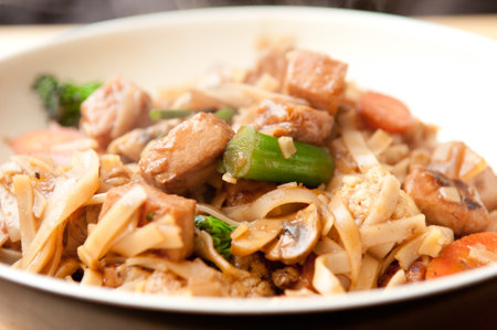 Tasty noodles with pork, broccoli, mushrooms, and carrotの写真素材