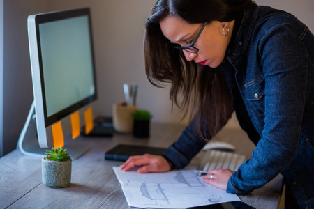 A closeup of a French confident female architect working on her new project in the officeの写真素材