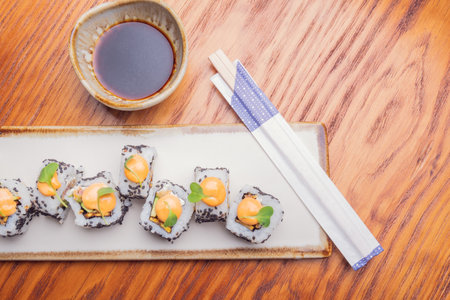 A top view of sushi rolls with sesame seeds on a white plate