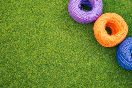 A closeup of colorful thread yarns on the grass with a copy spaceの写真素材