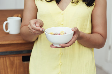 Close-up of a woman having breakfast at home. Domestic life concept.の写真素材