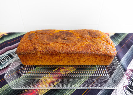 A tasty orange sponge cake on a tray in white background