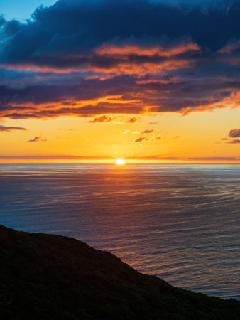 Sunset over Tasman sea at Piha beach, Auckland, New Zealandの写真素材