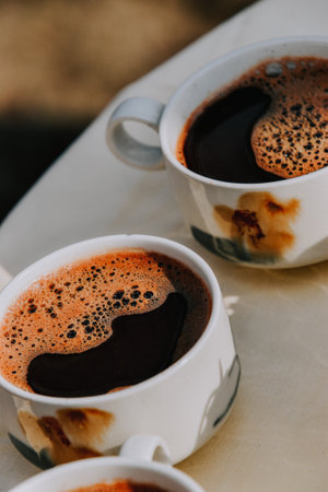 A vertical shot of two cups of coffee on a tablの写真素材