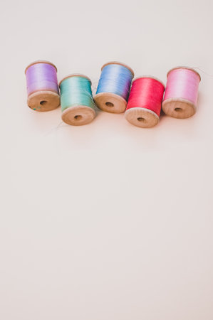 A colorful sewing threads on a light background with free space for text