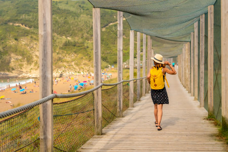 Young and adventurous girl enjoying summer vacation walking alone along the beachの写真素材