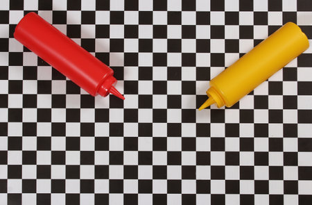 Ketchup and Mustard Bottles on Checkered Tableの写真素材