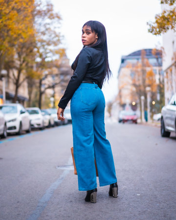 Fashion photo to a beautiful black girl of African ethnic group. Enjoying the vacation walking around the city with a bagの写真素材