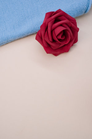 A closeup of the decorative artificial red rose on the blue fabricの写真素材