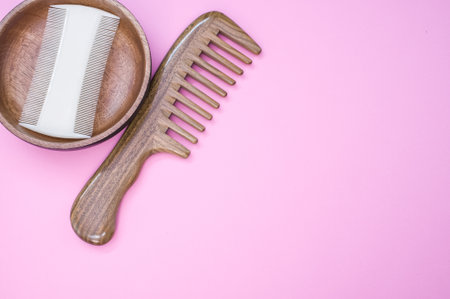 A closeup shot of scissors and hair comb on a pink surface - copy spaceの写真素材