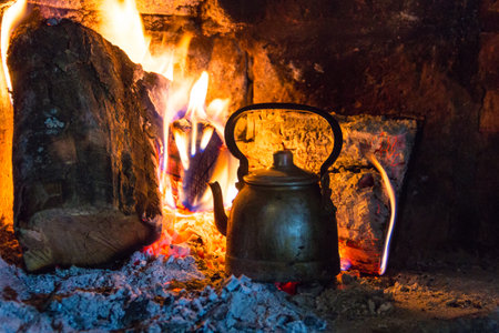 wood stove with kettle heating the water in the fieldの写真素材