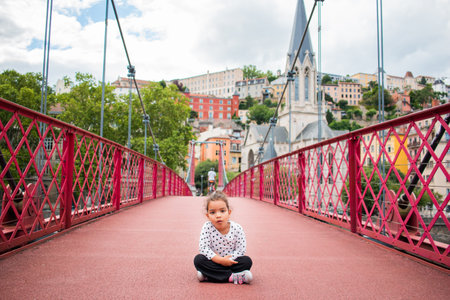 A portrait of little girl playing on a bridge on vacation in europeの写真素材