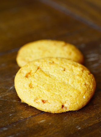 Two butter cookies on a wooden background