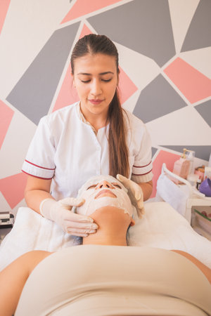 Young Woman Enjoying a Day at the Spa. Performing different treatments for the care of your skin and face.の写真素材