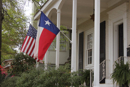 Historic Home With Texas and American Flags Springtimeの写真素材