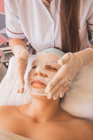 Young Woman Enjoying a Day at the Spa. Performing different treatments for the care of your skin and face.の写真素材