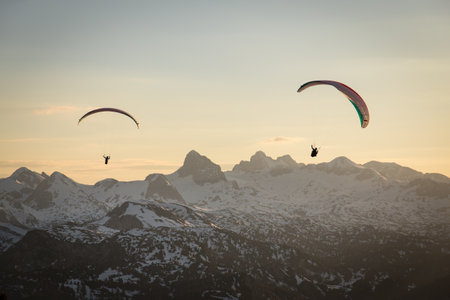 Paraglider couple flying over the mountains in Austria during sunsetの写真素材