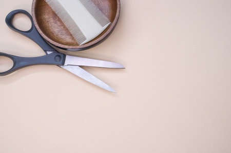 A closeup shot of scissors and hair comb on a beige surface - copy spaceの写真素材