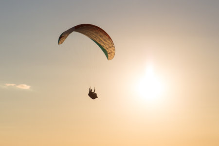 Paraglider  flying over the mountains in Austria during sunset