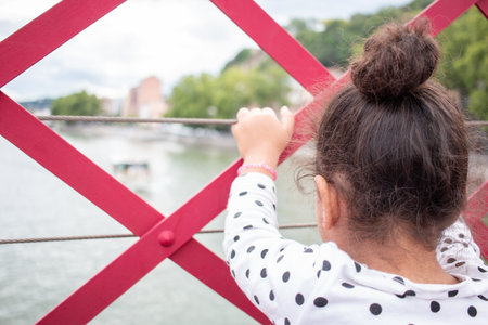 A portrait of little girl playing on a bridge on vacation in europeの写真素材