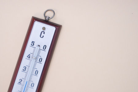 A top view of a thermometer on cream surface with a copy space