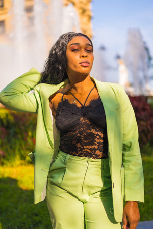 Lifestyle of a young girl of black African ethnicity with a beautiful green suit. The tourist perched in a beautiful water sourceの写真素材