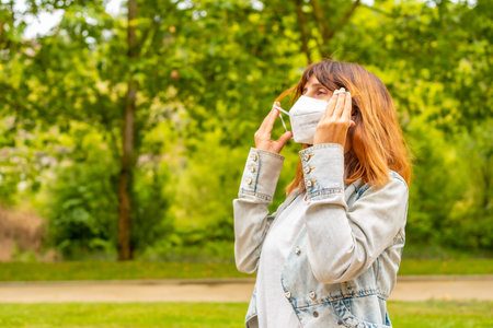 A woman removing her surgical mask at the end of the coronavirus pandemic restrictionの写真素材
