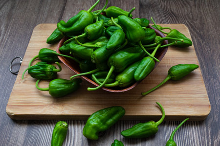 Raw green bell peppers in a bowlの写真素材