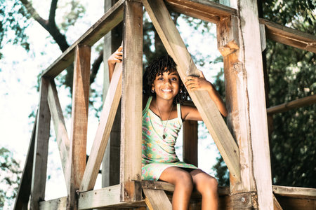 portrait of a small afro american girl sitting looking at the camera. childhood happiness conceptの写真素材