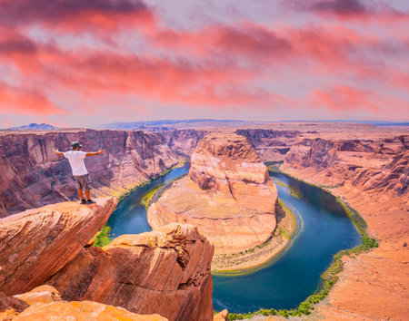 A young man with white shirt and green hat in Horseshoe Bend, Arizona. United Statesの写真素材