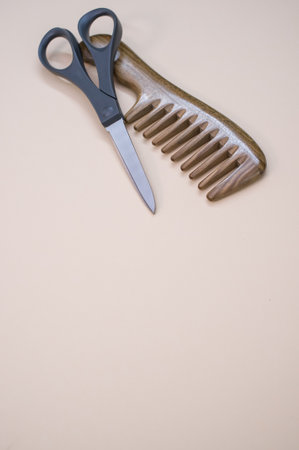 A vertical shot of a hairbrush and scissors on a plain backgroundの写真素材
