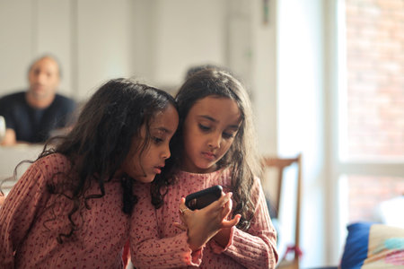 two young sisters use a smartphone